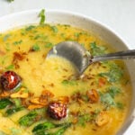 a dish of masoor ki daal with a spoon in it