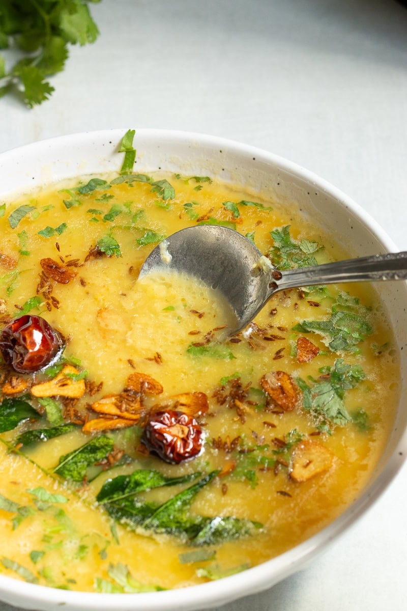 a dish of masoor ki daal with a spoon in it