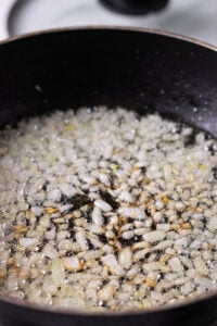 onions being sauteed in a wok for hara masala chicken