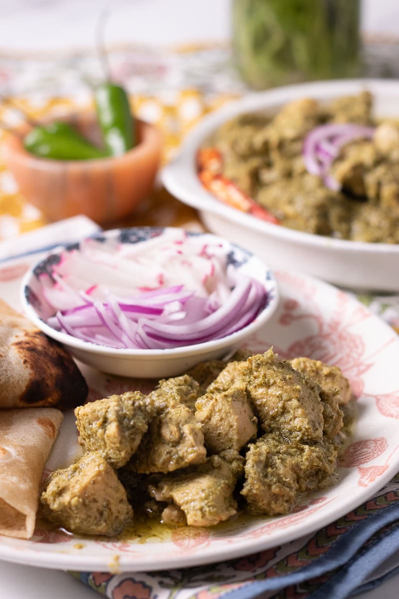 hara masala chicken with roti and onions, serving dish of haryali chicken in background