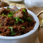 a small pot with tamatar gosht
