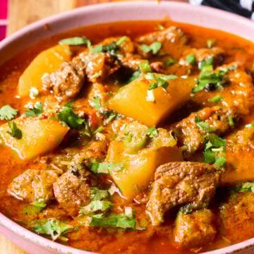 A bowl with Aloo Gosht, a meat and potato stew.
