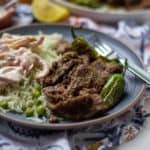 Pasanday on a plate with raita and a patterned napkin underneath