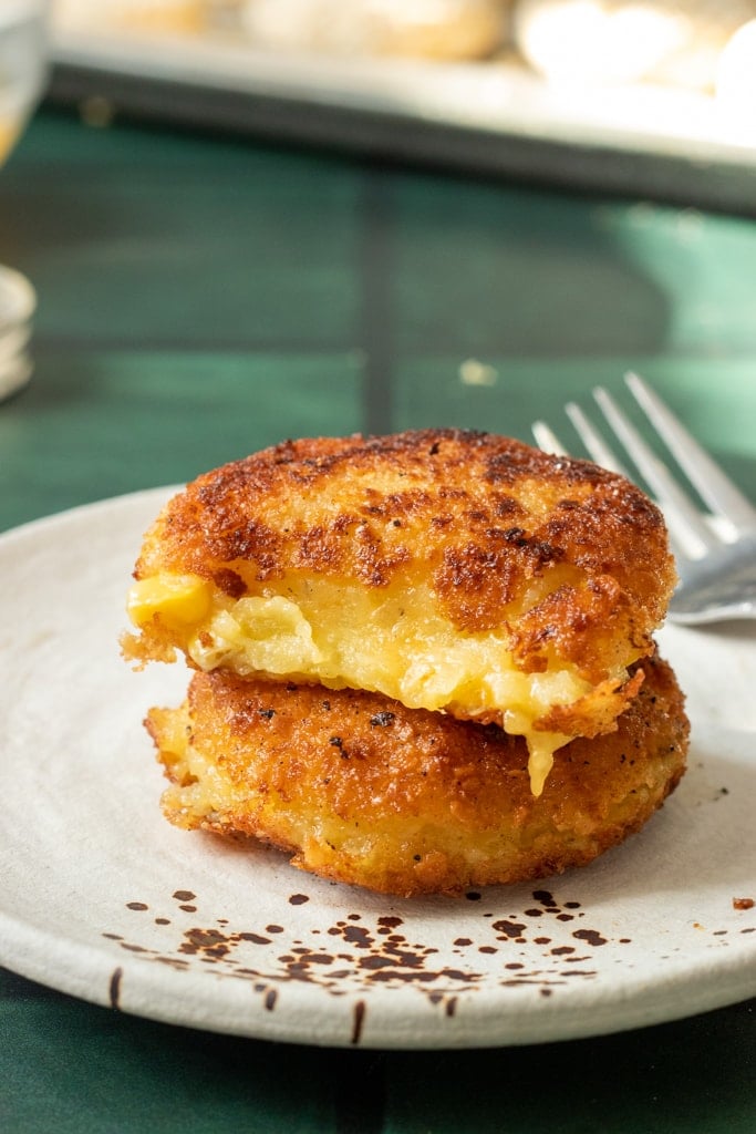 Aloo Cutlets stacked on top, one piece eaten out of the top one from this Potato Cutlets Recipe