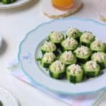 Cucumber Cream Cheese Rounds in a plate along with glasses of juice