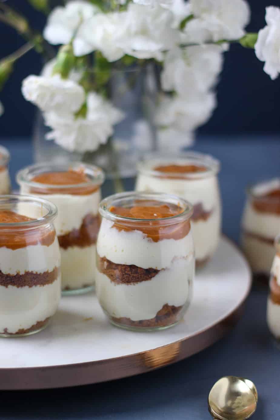 front view of cheesecake jars on a round marble platter