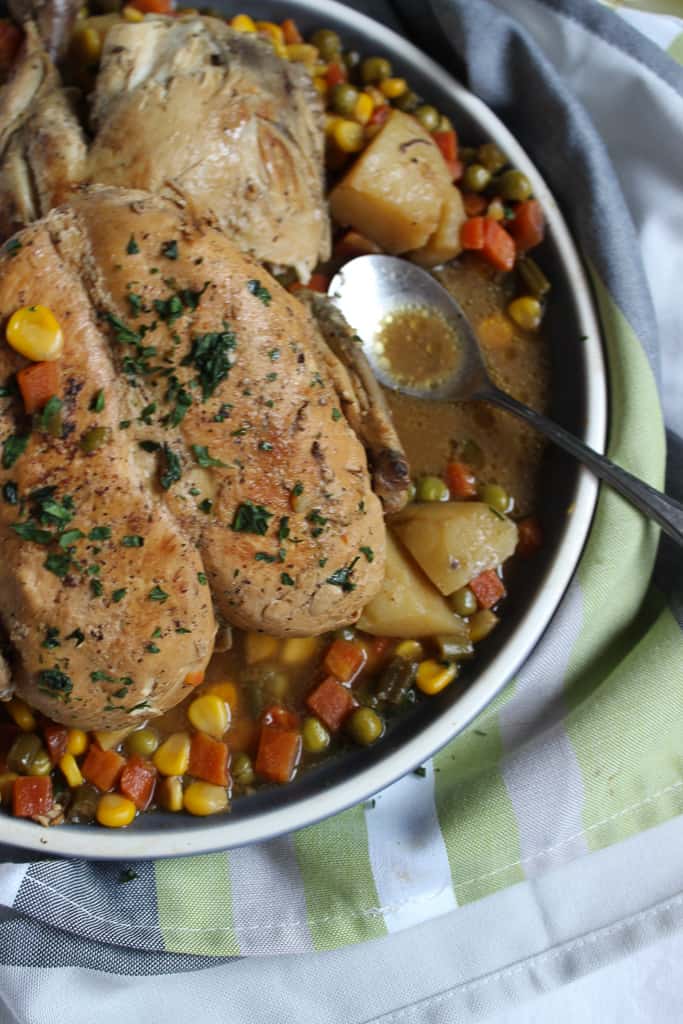 a Platter with Lemon Chicken Roast in it and a spoon resting in some broth