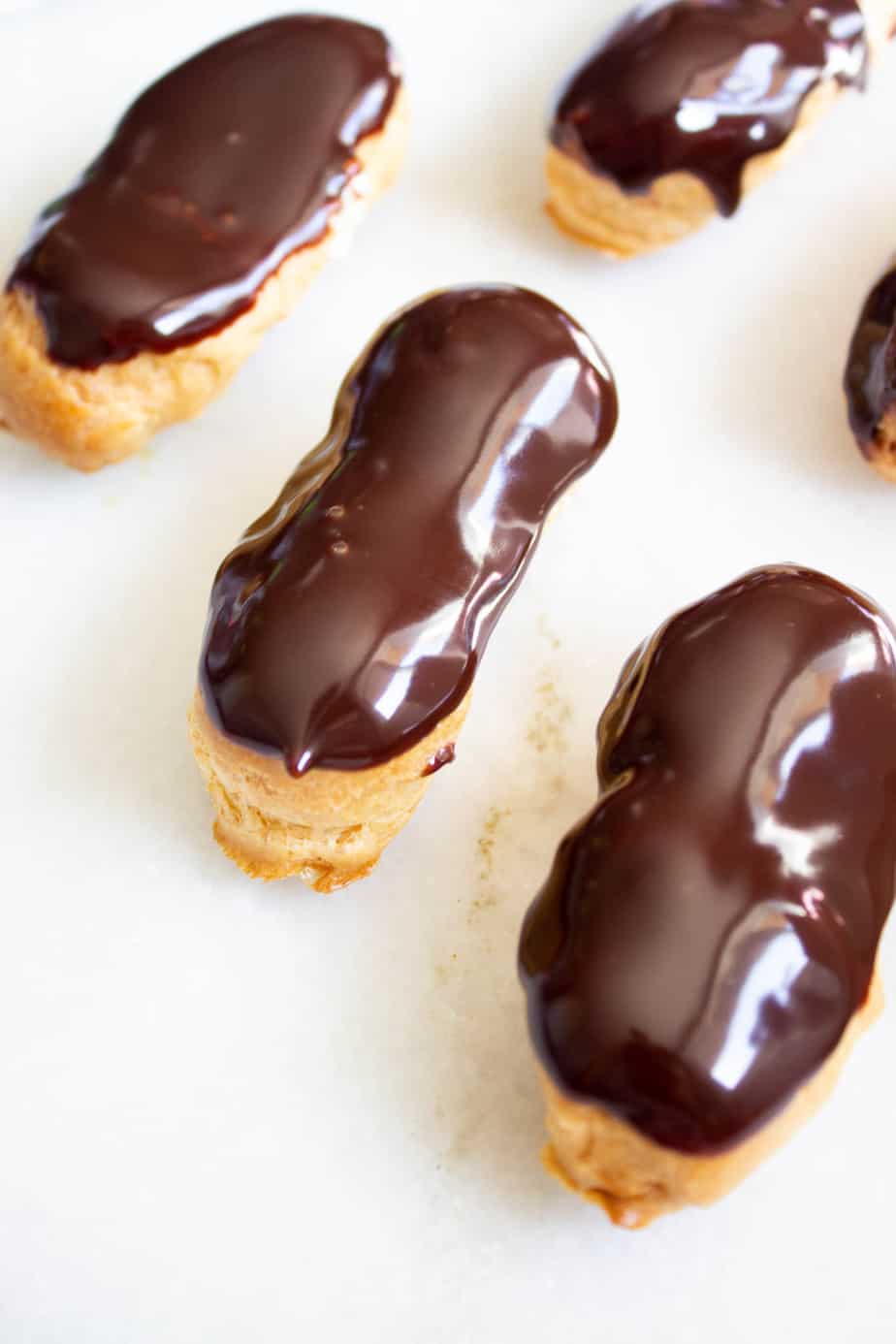 Three eclairs on a marble surface