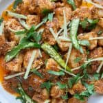 a close up of a dish of Karhai Chicken with green chilies,ciilantro and ginge
