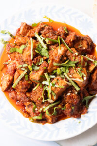 chicken masala ready, top down view in a white plate