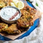 ¾ view of a plate of cauliflower fritters with the mint yogurt in the center