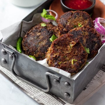 Instant Pot Shami Kababs in a rectangular tray with a dipping sauce and tea in the background