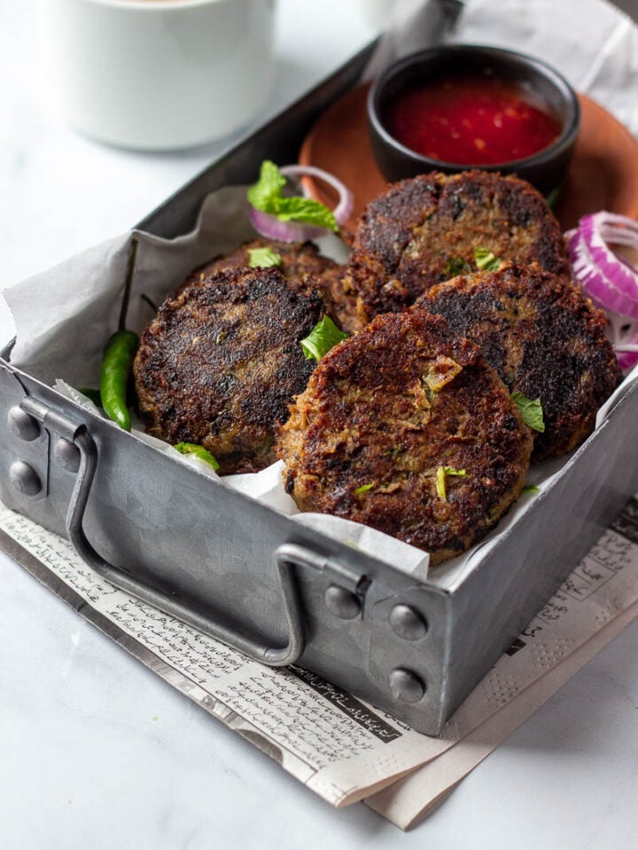Instant Pot Shami Kababs in a rectangular tray with a dipping sauce and tea in the background