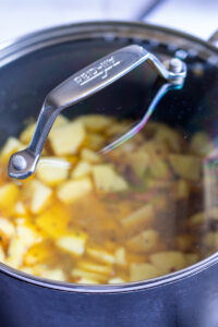 potatoes simmering covered in a pot