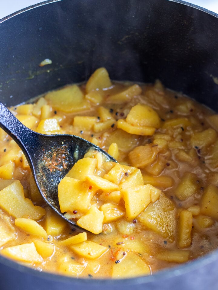 aloo poori aloo in a black pot