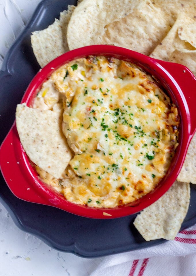 Corn dip with chips around it and one inside