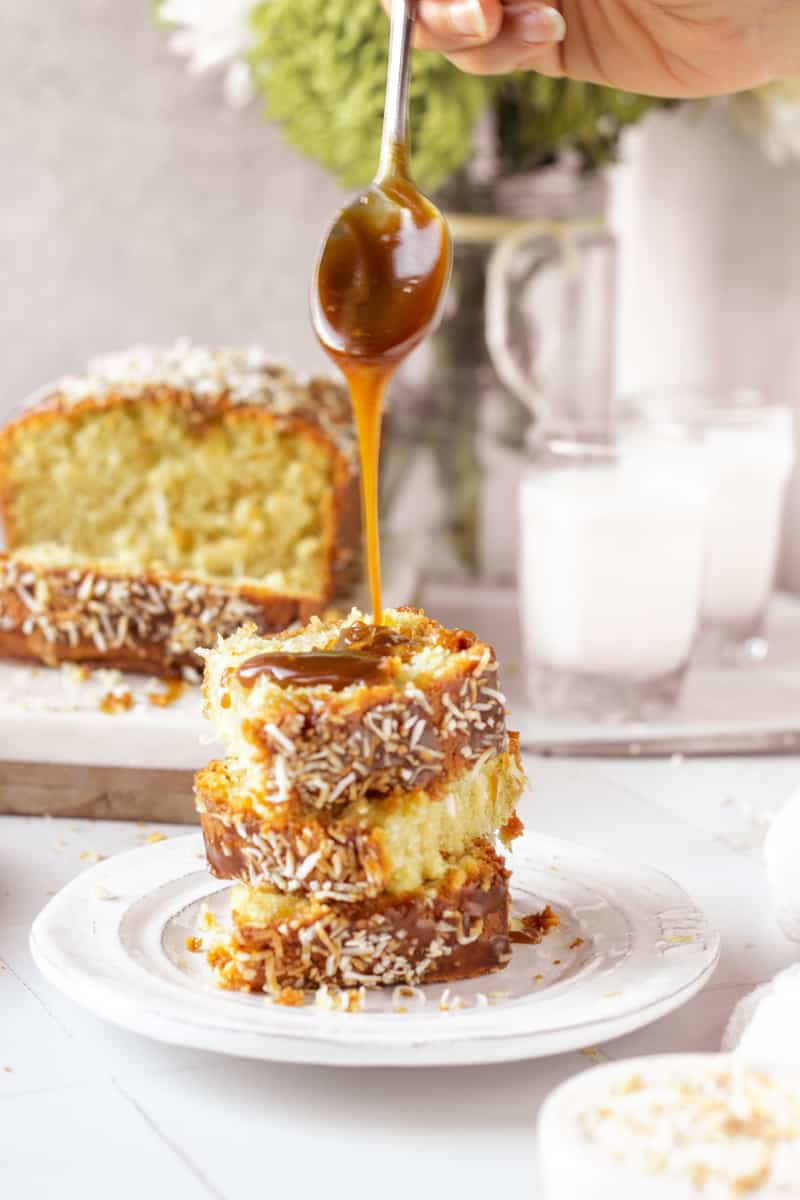 stack of coconut loaf cake slices with caramel drizzling over top