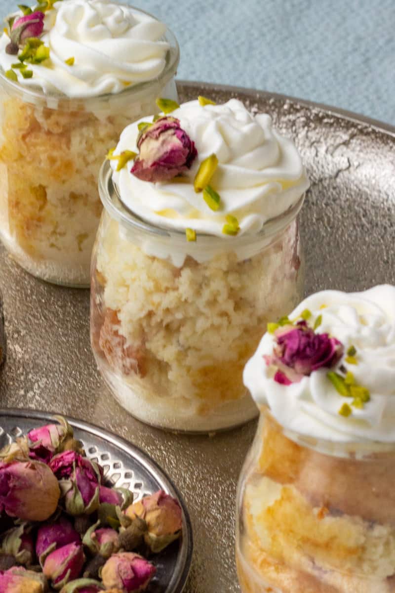 Ras Malai Tres Leches Cake jars with a little bowl of roses on a tray
