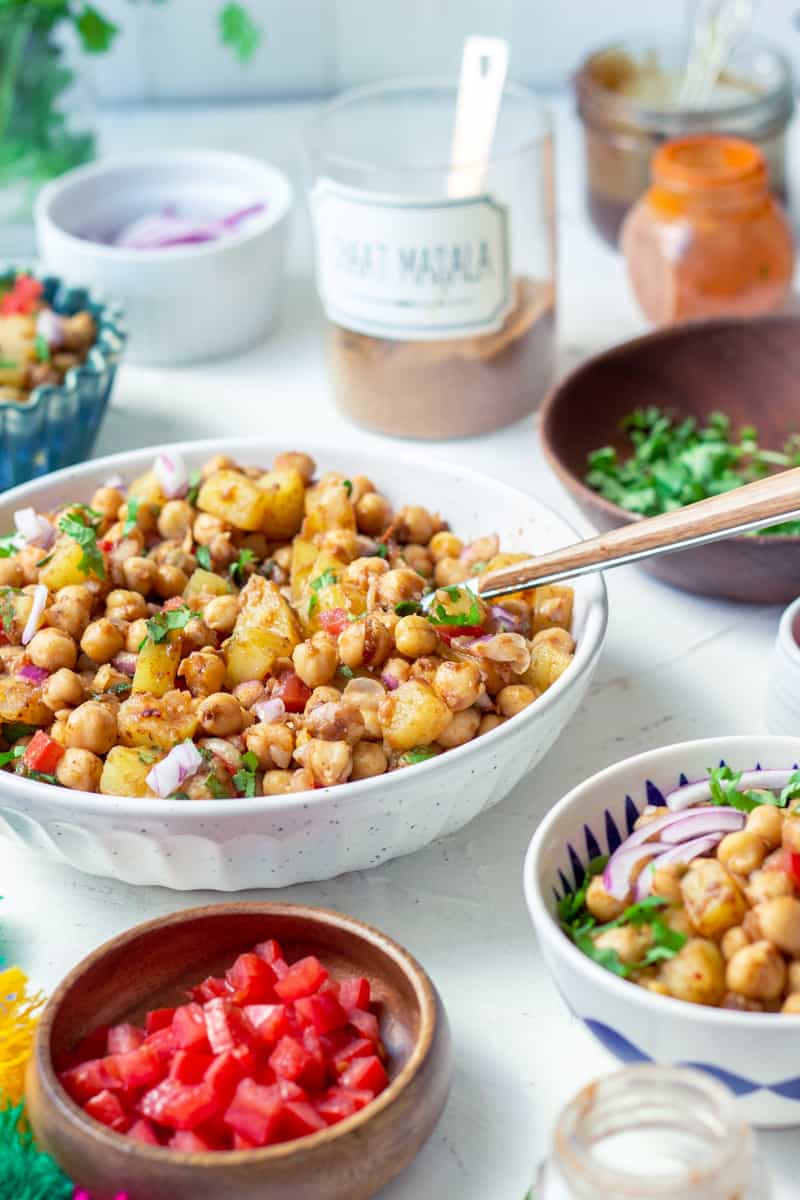 Chana Chaat in a bowl with a spoon, a little cilantro