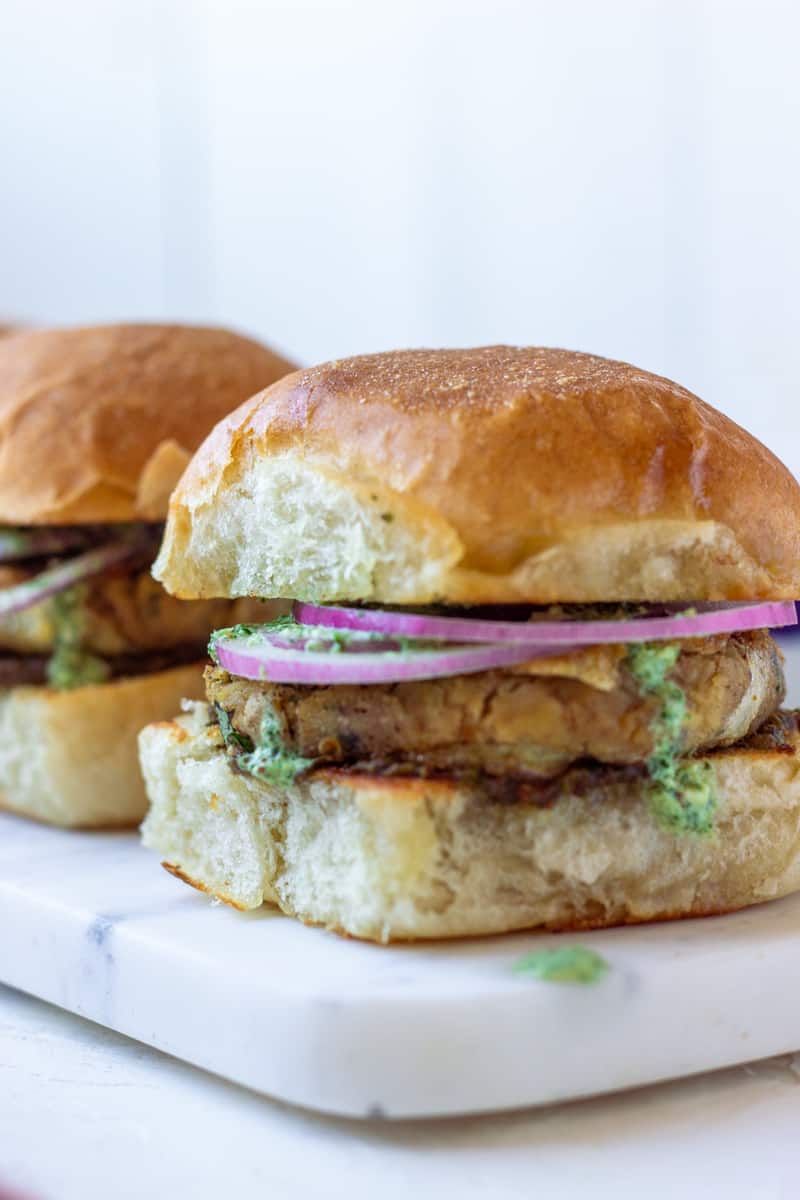 A Bun Kabab with chutney dripping on the sides