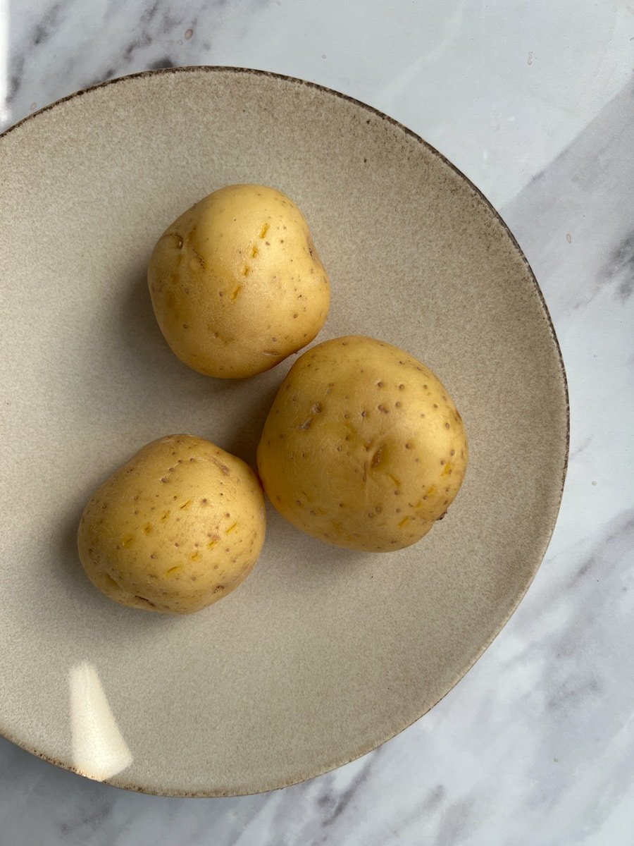 Potatoes pierced with a fork ready to cook in the microwave