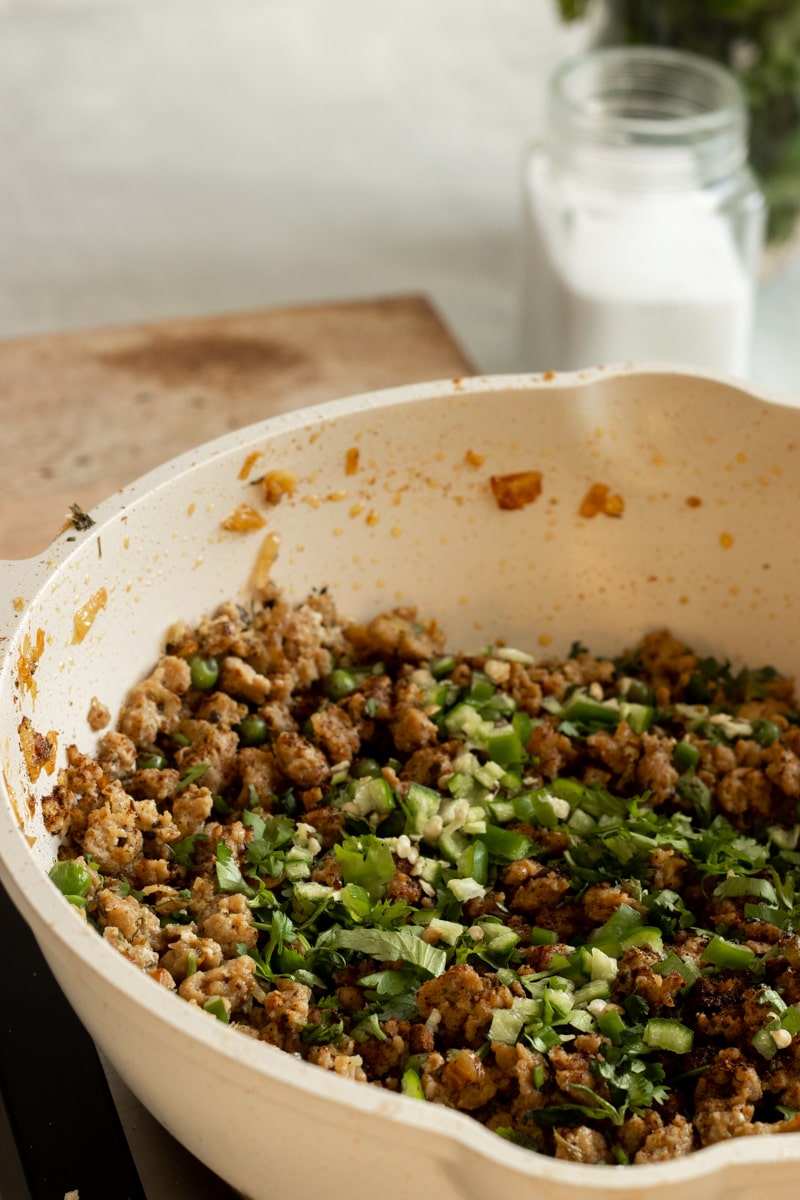 saute pan with cooked keema garnished with cilantro and chilies