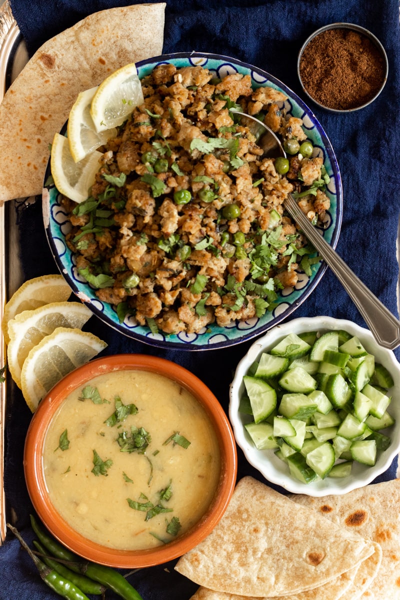 chicken keema, daal, roti, cucumber on a tray