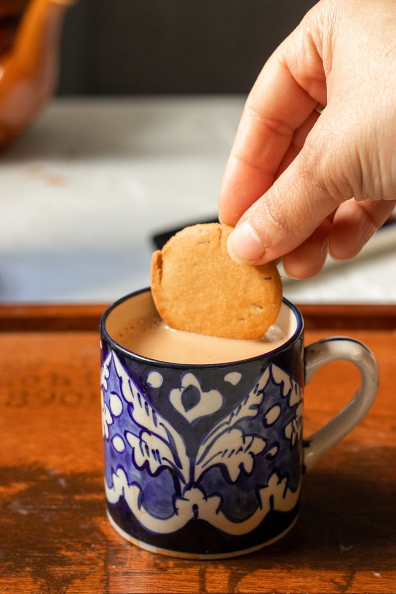 a biscuit being dipped into tea