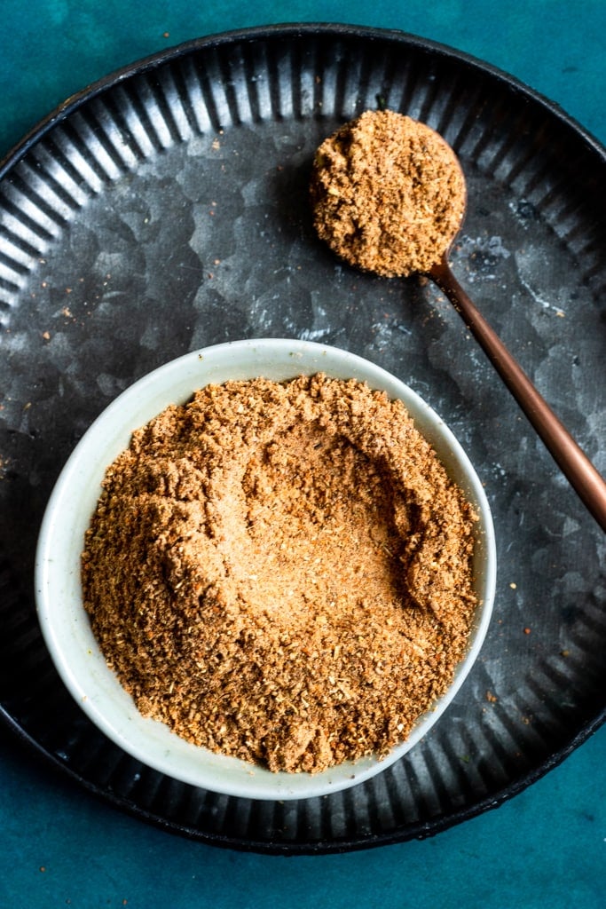 chaat maslaa in a bowl, a spoonful of chaat masala on the side