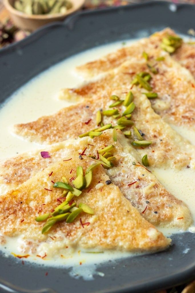 Shahi Tukray arranged in a platter and garnished with nuts and saffron