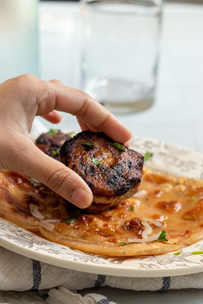 childs hand picking up a chicken kabab