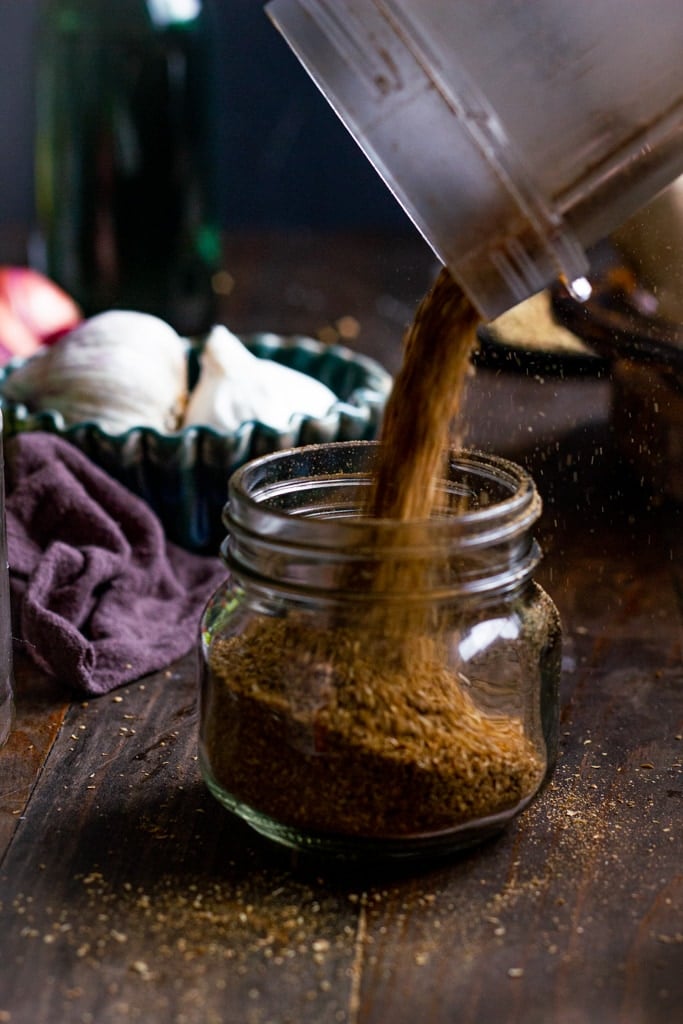 Coriander powder being poured into a jar