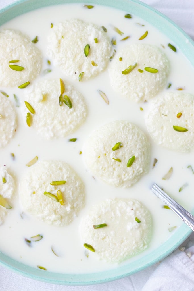 Top down view of a dish of rasmalai garnished with pistachios
