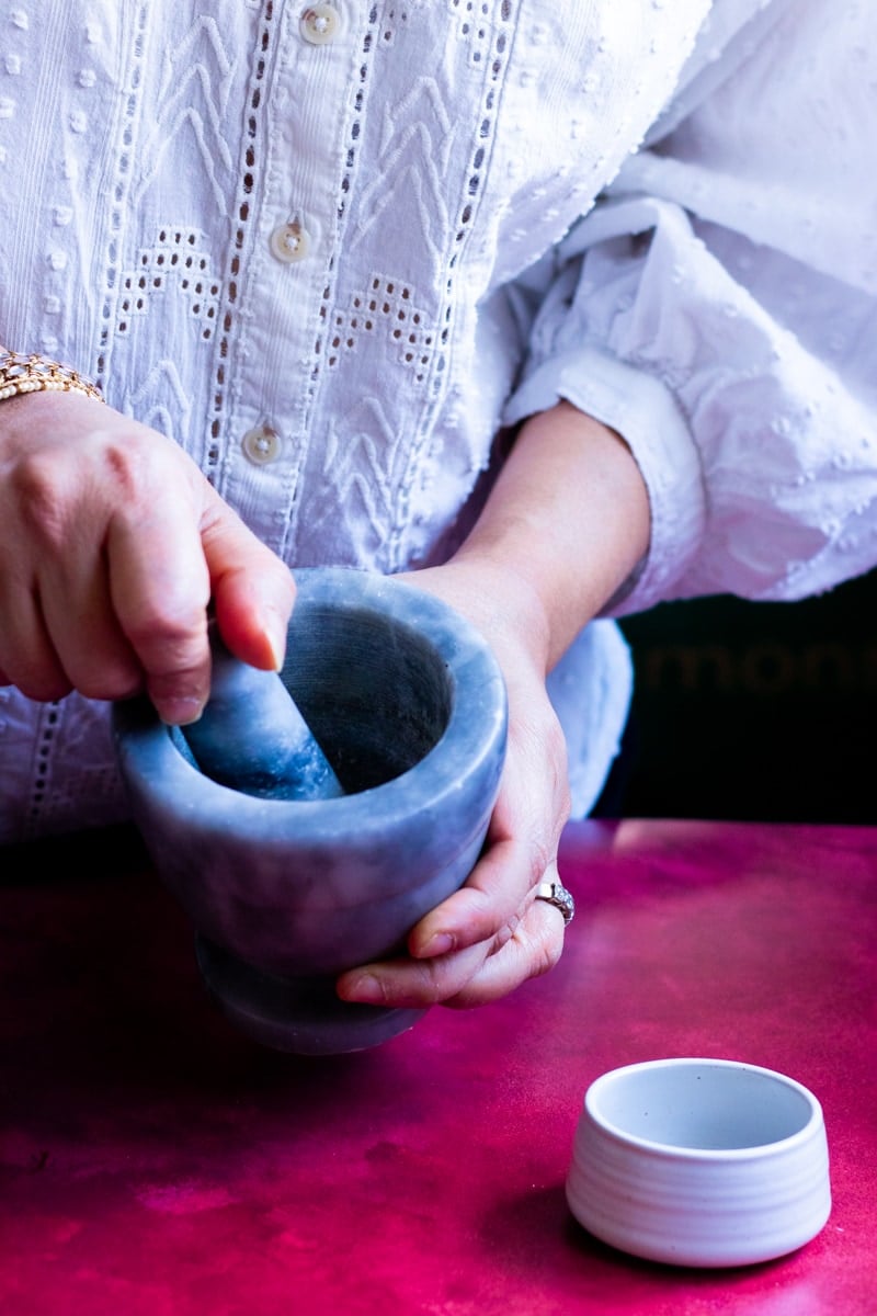 someone freshly grinding cardamom for kheer in instant pot