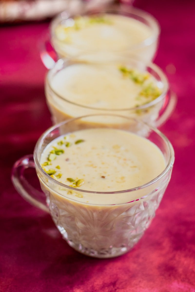 three crystal cups garnished with chopped pistachios, rice instant pot kheer inside.
