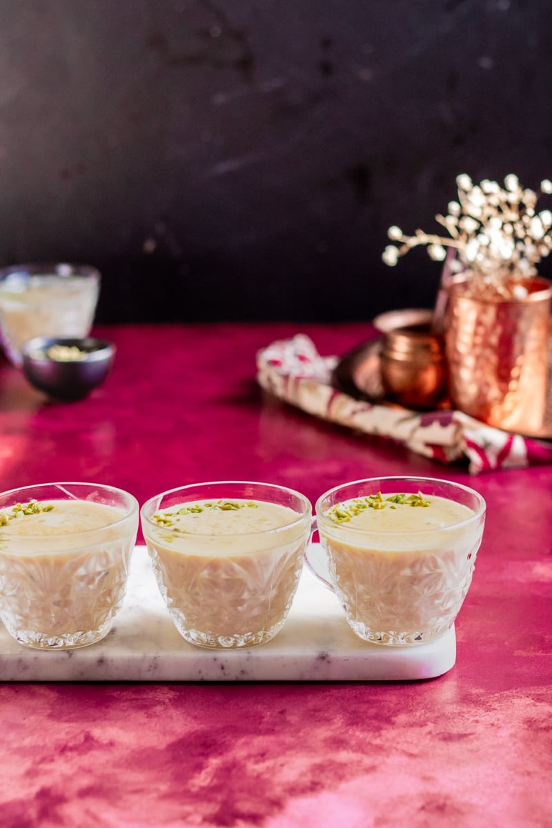 Instant Por Kheer in cups, a dark background with babys breath flowers and other decorative ellements.