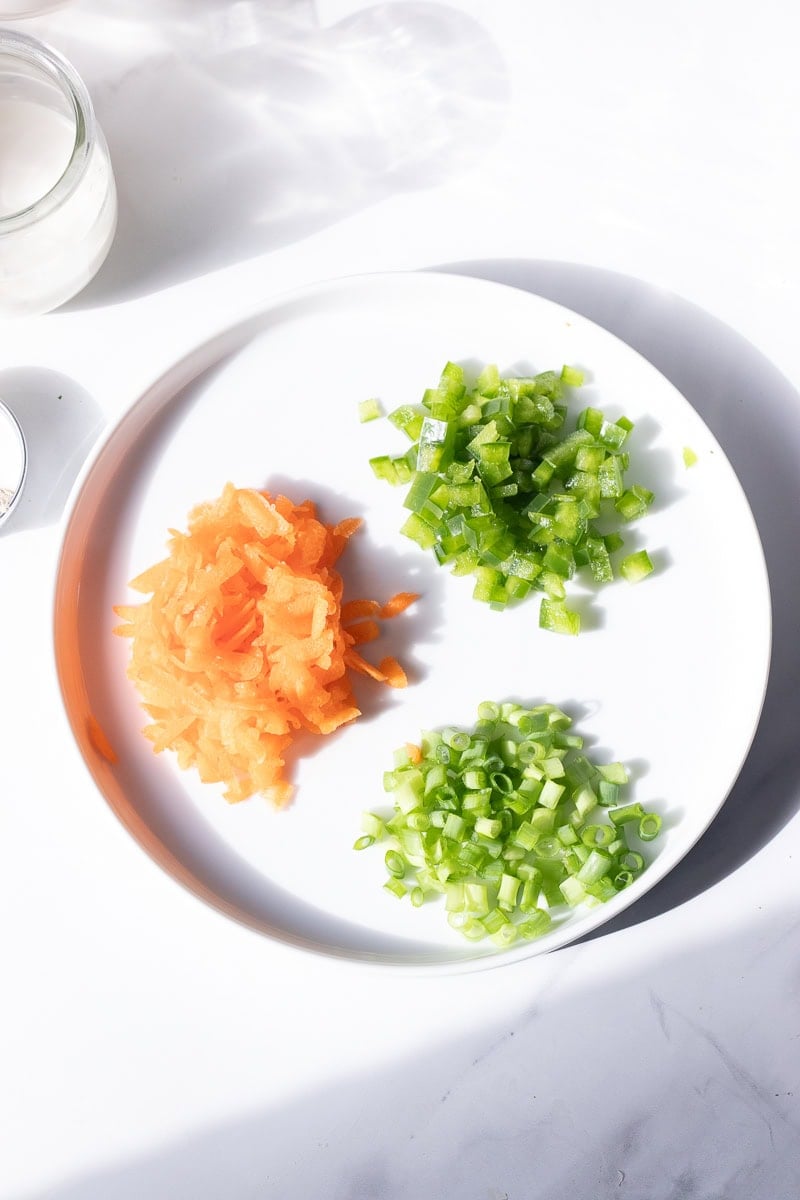 top down view of veggies to add in - diced peppers, shredded carrot and sliced green onions