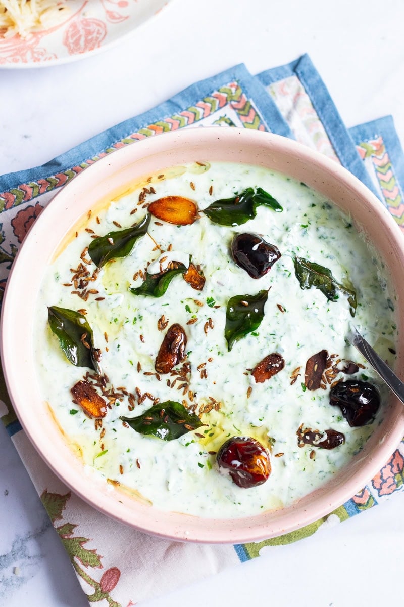 top down view of spinach raita in a pink bowl