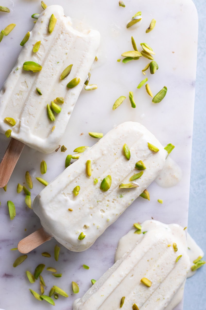 top down view of pista kulfi with some pistachios scattered over top.